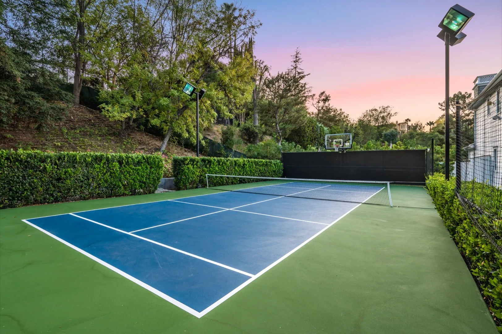 Tennis courts within a Dubai residential community surrounded by villas and greenery