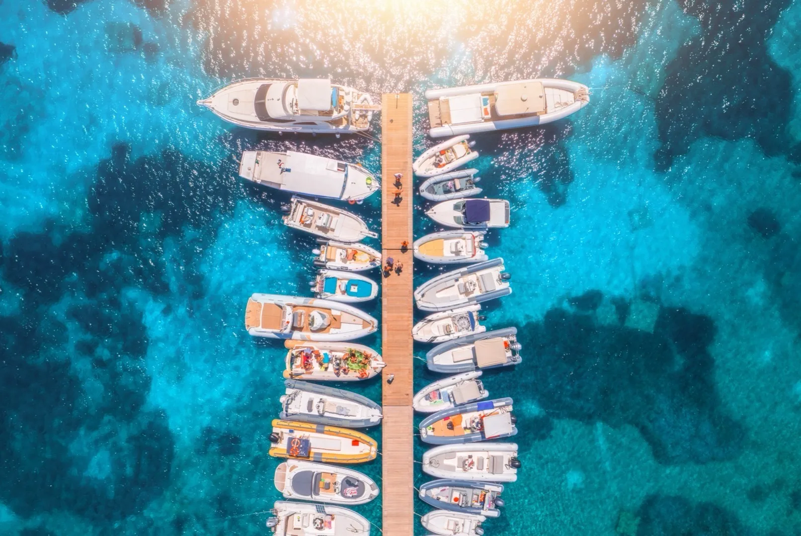 Aerial view of Dubai Marina waterfront with luxury yachts berthed along the promenade