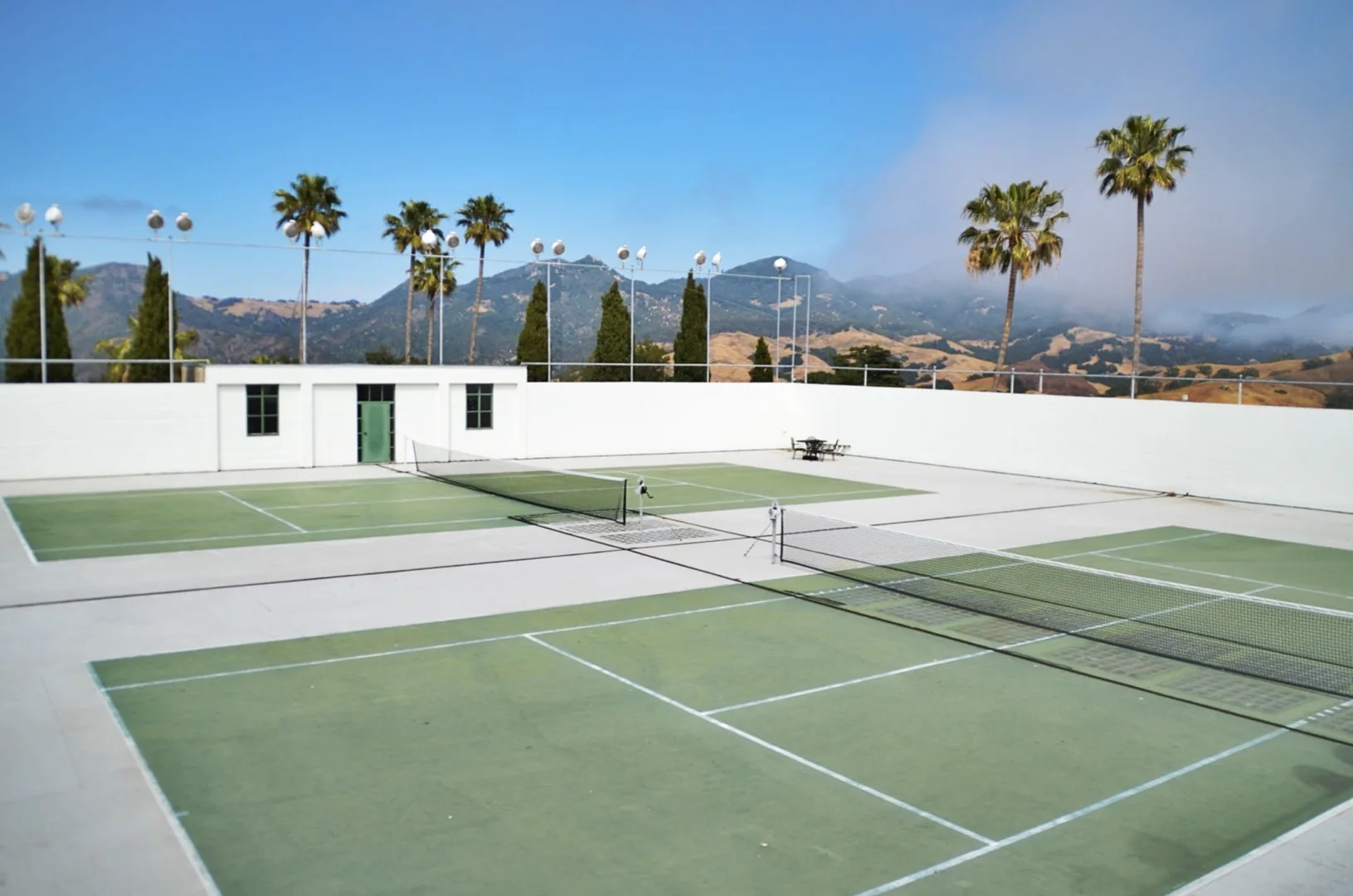 Floodlit tennis courts at sunset in a Dubai residential community